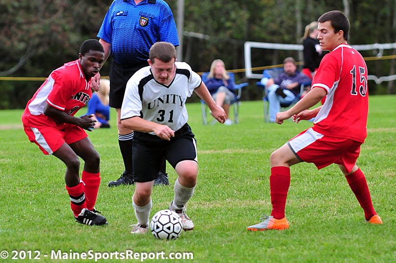 Unity’s Jacob Scoville (31) moves the ball between CMCC’s Darine Gnidehouse (9) and Clifford Turner, center, splits the CMCC defense during the men’s game Friday. CMCC won the game 1-0. (Photo Courtesy of Skip Hawkes)