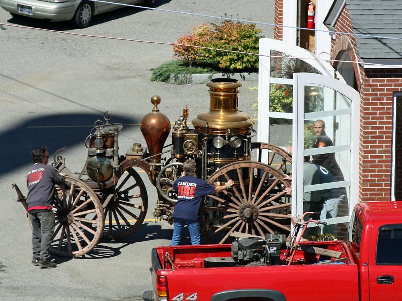 Many hands are needed Tuesday to move Camden's antique steam fire pumper.