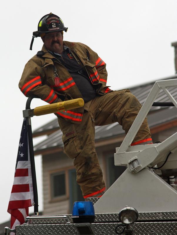 Thomaston firefighter Tony Leo mans the ladder Saturday.