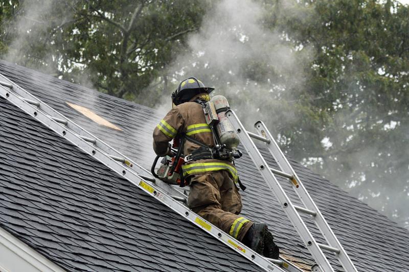 A chainsaw is used to cut another vent hole in the roof Saturday. (Photo by Holly S. Edwards)