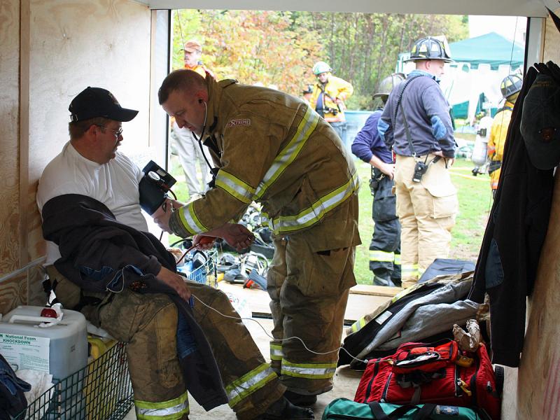 Joe Moore, of Rockland EMS, checks Jerry Harjula's blood pressure during live fire training in South Thomaston Sept. 29. (Photo by Holly S. Edwards)