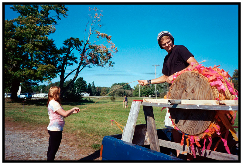 THORNDIKE – Volunteers Parker Weyer, right, and Anissa Nelson unspool a roll of twine made visible by bright ribbons used to mark the parking areas for the Common Ground Fair.