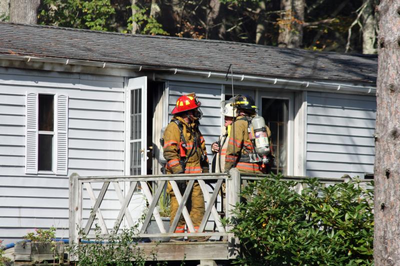 Firefighters remained at the house after the fire was knocked down, looking for hotspots in the walls and ceiling. (Photo by Holly S. Edwards)