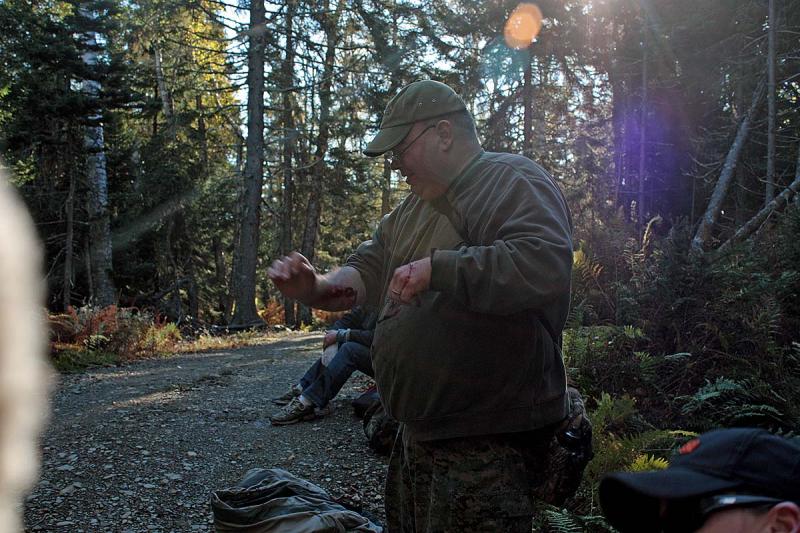 Another volunteer victim gets a fresh dose of fake blood before climbing down into a 5-foot-deep hole to await 'rescue' in the Lasell Island exercise Oct. 13. (Photo by Holly S. Edwards)