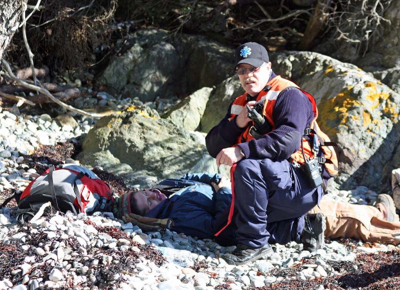 Radioing in injuries and calling for immediate transport of a 'gravely injured victim' during Saturday's mass casualty drill on Lasell Island. (Photo by Holly S. Edwards)