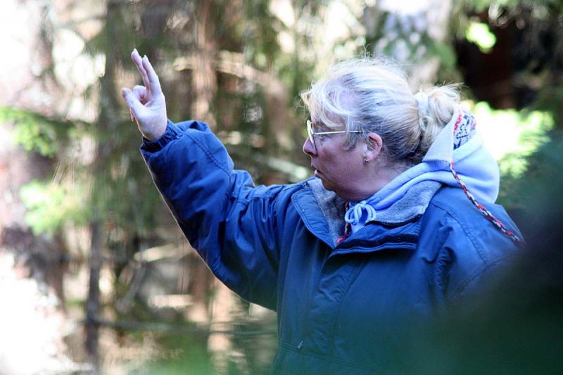 While searching the woods for additional victims, a rescuer uses her hand and voice to signal that she has 'found two.' (Photo by Holly S. Edwards)