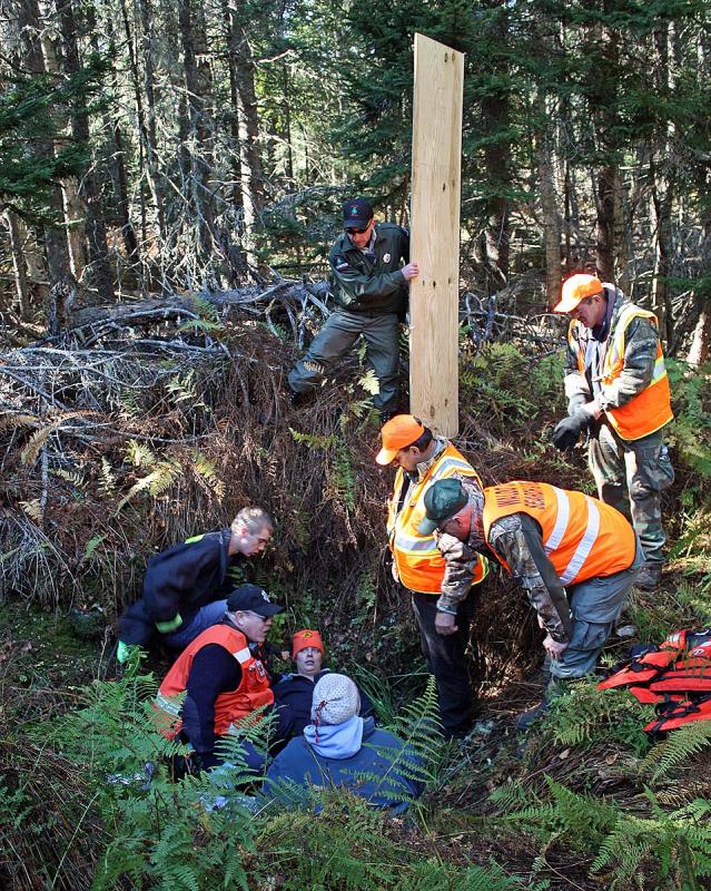 Rescuers plan the steps they will take to remove this 'injured victim' from the hole. (Photo by Holly S. Edwards)