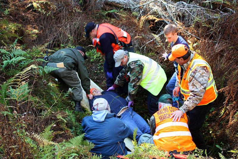 Rescuers first have to move the volunteer victim onto the board, without causing further injury. (Photo by Holly S. Edwards)