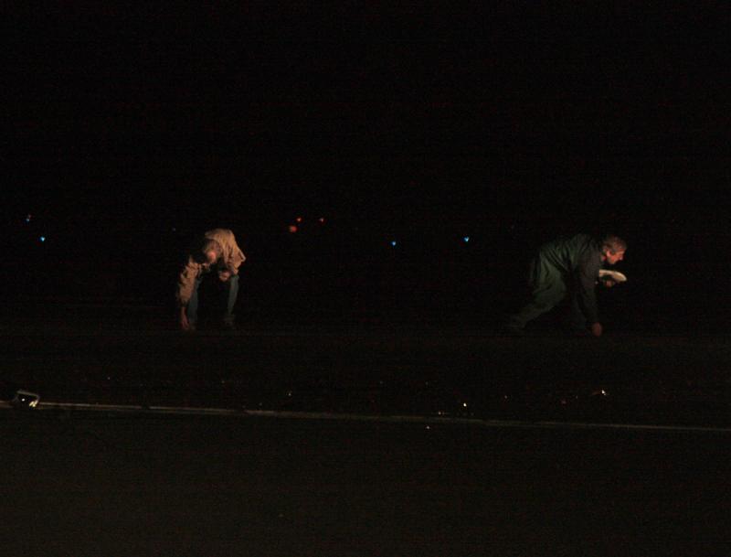 Knox County Regional Airport Manager Jeff Northgraves, right, and anothe rman pick up debris from Friday night's plane crash. (Photo by Holly S. Edwards)