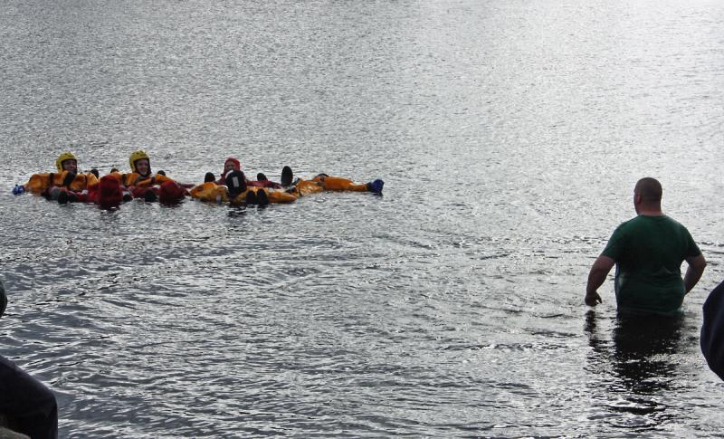 A group of firefighters await Justin Hills' entrance into Norton Pond to test their water rescue skills. (Photo by Holly S. Edwards)