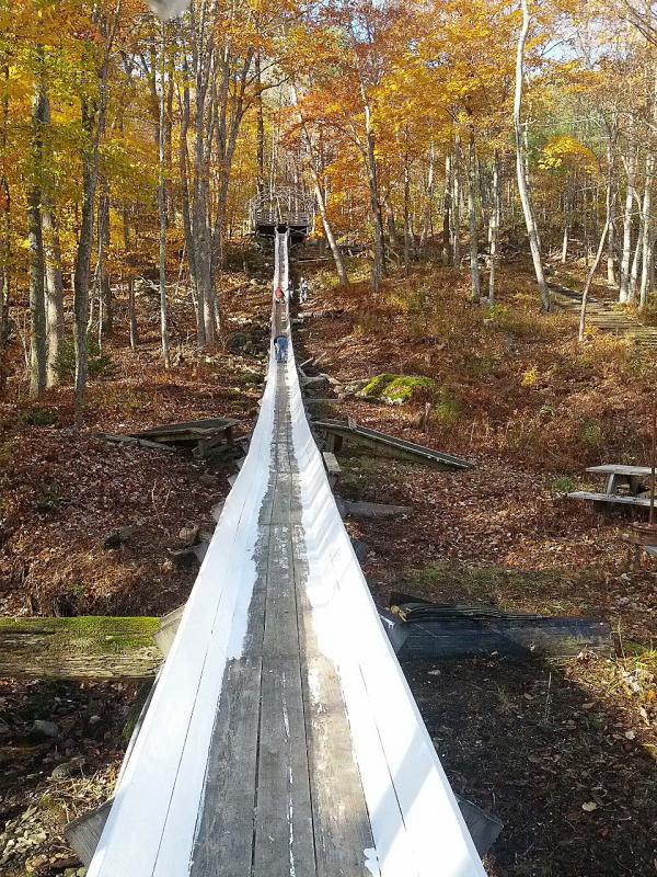 A couple of weeks prior to painting Oct. 26, West Bay Rotary scraped and sanded the Camden Snow Bowl's 400-foot-long wood toboggan chute. (Photo courtesy Sandy Cox)