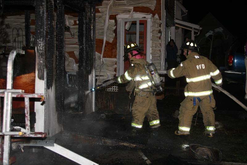 Rockland firefighters Katy Vanorse and Mike Root put water on hot spots during Tuesday night's shed fire on Berkley Street in the city. (Photo courtesy Rockland Fire Department/by Alan Athearn).