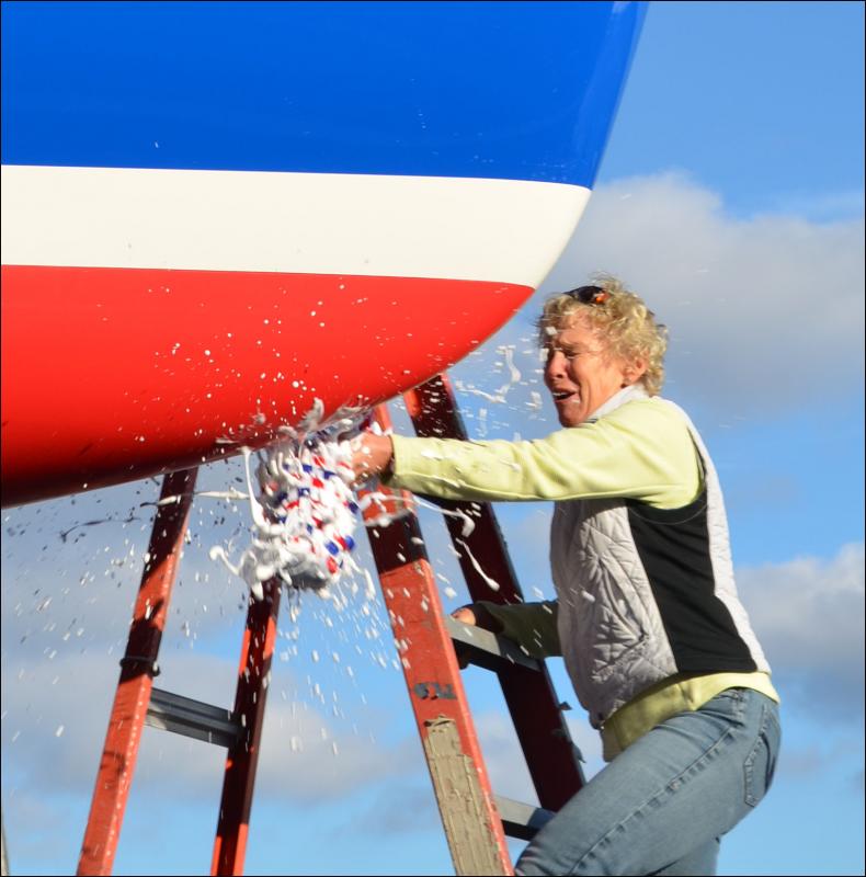 Heidi Lyman bursts a bottle of champagne in a traditional boat christening to bless the seamen and vessel.