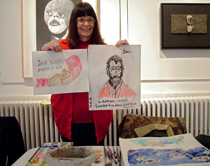 Suzanna Lasker of Jefferson holds up two portraits she painted of Vietnam veteran Ian Collins of LIberty painted during an Armistice/Veterans Day draw-a-thon at Waterfall Arts. (Photo by Ethan Andrews)
