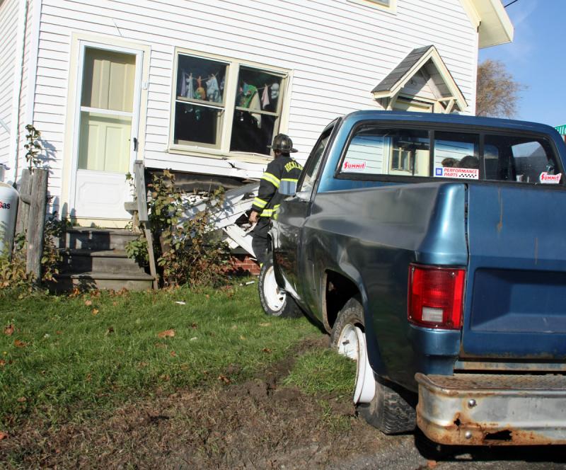Rockland Fire Lt. Francis 'Rick' Johnson inspects damage to the Puddleducks Thrfit Boutique Monday morning after 18-year-old Christopher Prescott crashed his pickup truck into it. (Photo courtesy Rockland Fire Department/by Alan Athearn)
