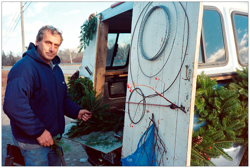 Larry Carrozzo ties his $5 christmas wreaths out of the back of his truck on Route 1 in Searsport.