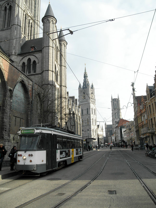 Ghent in a nutshell: Tram stop at the feet of cathedral number one, belfry and cathedral number two in the background. See any cars? (Photo by Ari Snider)