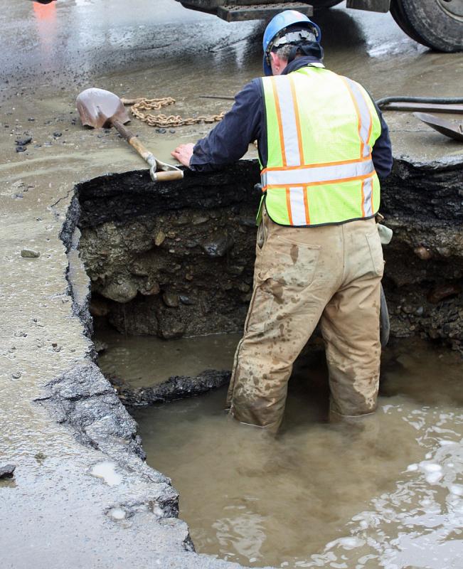 Working with a jackhammer to break up large chunks of pavement slows pumping and allows water to fill the hole on Union Street. (Photo by Holly S. Edwards)