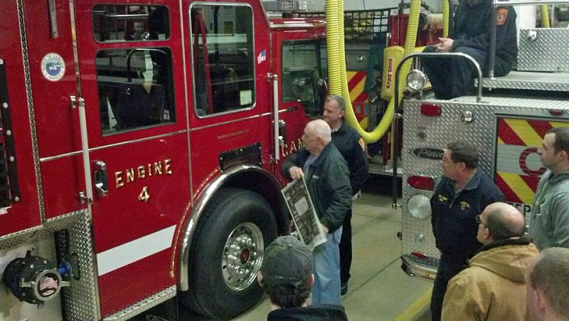 Harold Drikwater, a Camden firefighter since 1955, removes the paper covering his name on Engine 4. (Courtesy Ryan Fisher)