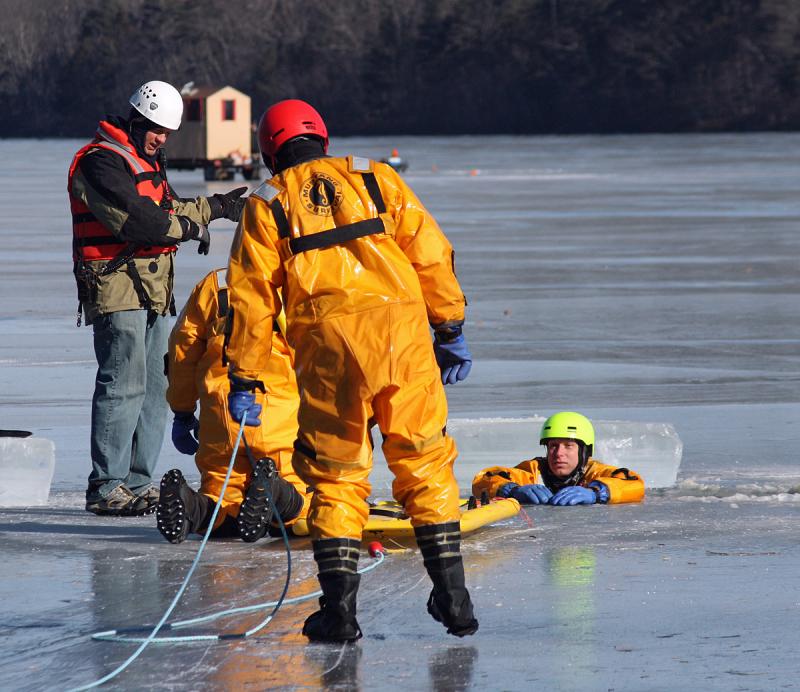 Rockland Fire Asst. Chief Adam Miceli, left, provides instruction during ice rescue training on Chickawaukie Pond in Rockland Saturday. (Photo by Holly S. Edwards)
