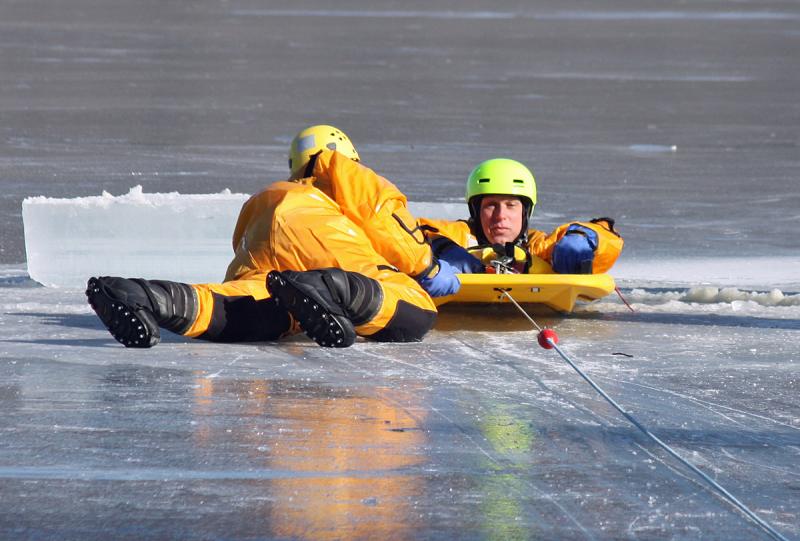 Firefighter Mike Cole is pulled onto the rescue sled during training Saturday on Chickawaukie Pond. (Photo by Holly S. Edwards)