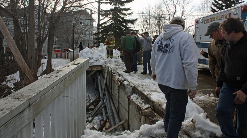 Camden Public Works employees join Camden First Aid and Camden Fire Department first responders at the site where the front-end loader went over the embankment Friday afternoon. (Photo by Holly S. Edwards)