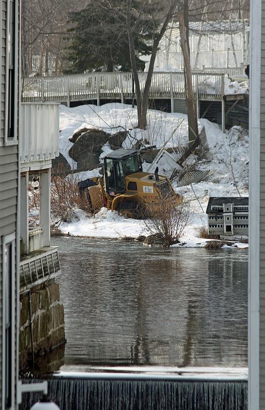 Moments after the 911 call, a front-end loader can be seen down an embankment at the mill pond above Knox Mill in downtown Camden. (Photo by Holly S. Edwards)