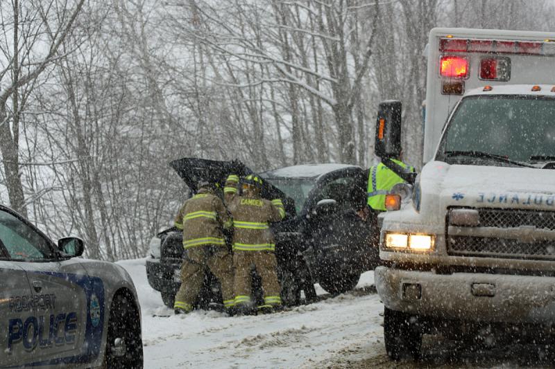 Camden firefighters disconnect the battery in Judith Carver's totalled Toyota pickup truck after she crashed it on Route 52 Sunday afternoon. (Photo by Holly S. Edwards)