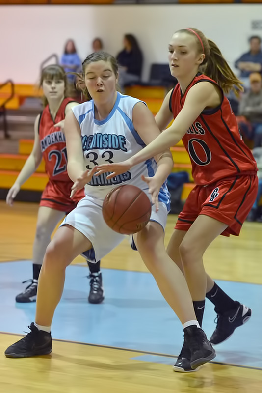 In the JV game, not only did Camden Hills Eliza Boetsch have a career high 21 points, but also played tough defense as Oceanside's Ashley Pezanowski finds out here. (Photo by Ron Hawkes)