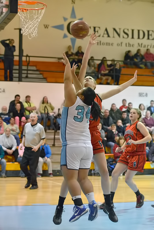Camden Hills Rachel Pease, back, gets her first block of the game as Oceanside's Danessa MacDonald trys to get a shot off past her. (Photo by Ron Hawkes)