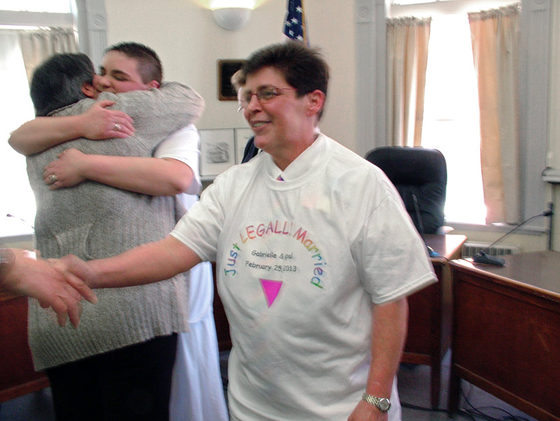 Gabrielle Eiholzer shakes hands with attendants after the ceremony while Opal Ash, left, gets a hug from her mother. (Photo by Ethan Andrews)