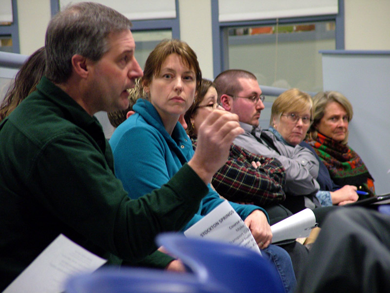 Stockton Springs resident and parent Ross Cottrell addresses his concerns to the RSU 20 board on Tuesday night. Kris Braga, behind Cottrell, also voiced reservations about a plan that would make major changes to the school. (Photo by Ethan Andrews)