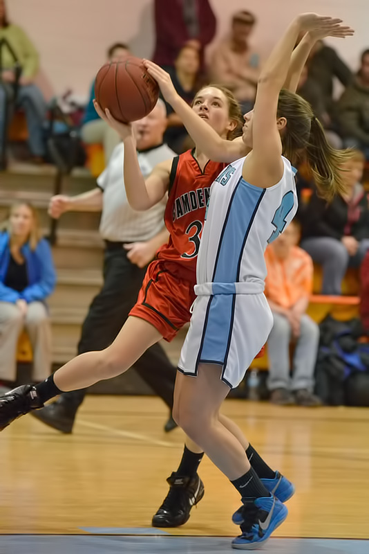 Camden Hills Megan LeGage drives to the basket for a lay up past the defense of Oceanside's Brooke Dugan. (Photo by Ron Hawkes)