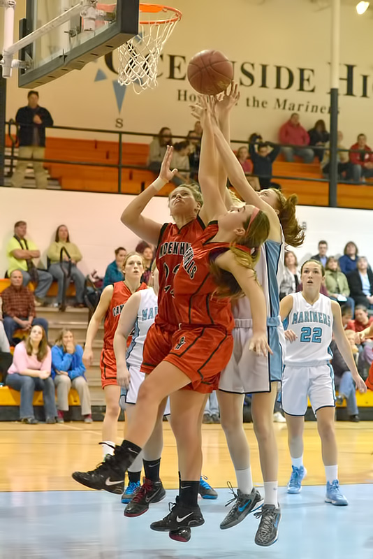 Oceanside's Phoebe ferraiolo, right, just gets a fingertip on the ball over Camden Hills, Bekah Hilt, left, and Kristina Alex. (Photo by Ron Hawkes)