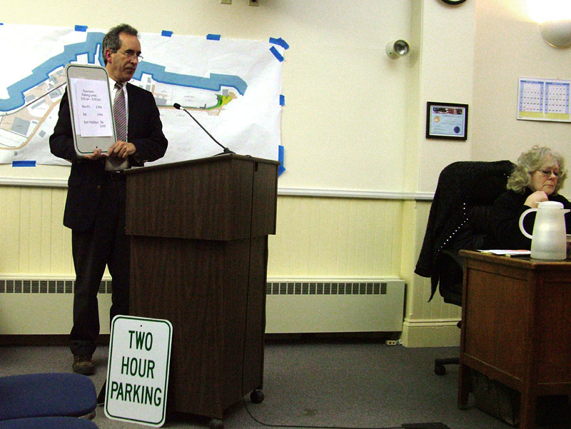 City Manager Joe Slocum shows a parking sign on which a paper lists new hours for downtown, daytime parking. The Council signed off on the signage (actual lettering would appear larger) during a meeting that featured a wide range of topics, from Front Street Shipyard to the Harbor Walk and RSU 20 Withdrawal. (Photo by Ethan Andrews) City Manager Joe Slocum shows a parking sign on which a piece of paper lists new hours for downtown, daytime parking. (Photo by Ethan Andrews)