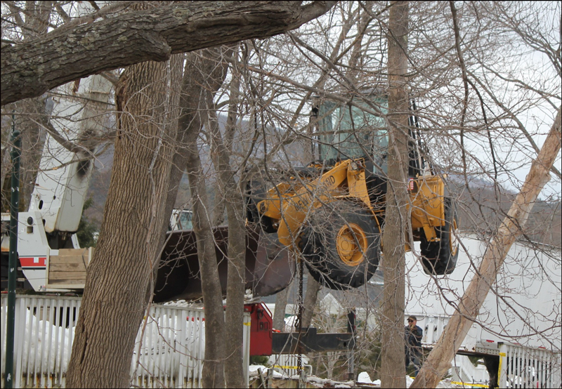 Soon after 9 a.m. on Saturday, Feb. 16, the front-end loader that had tumbled over the side of a 20-foot wall the previous day was being lifted back up from the river's edge with a crane. (Photo by Lori Van Dusen)