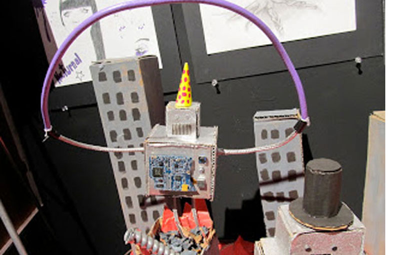 Jalina "Jolly" Brown on the whimsical cardboard robots tearing apart a city she made for an art project. “I just create random weird things that come out of my brain,” she said. (Photo by Kay Stephens)