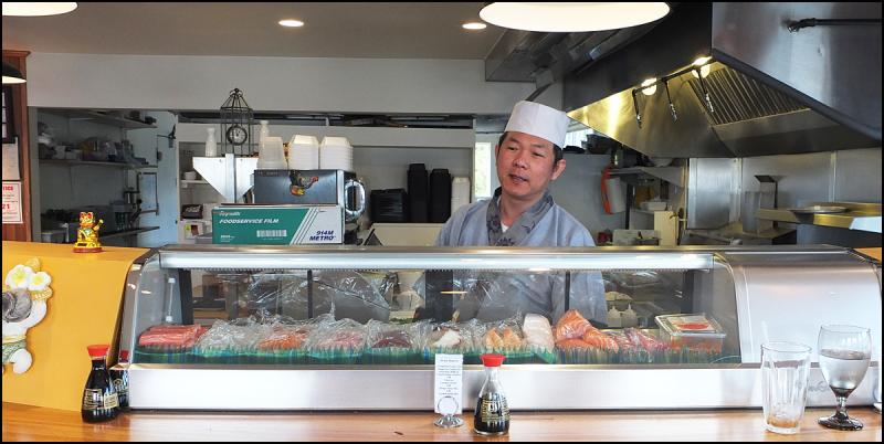 Mr. Wat at work in the open kitchen of his restaurant, which is named after him. (Photo by Chris Wolf)