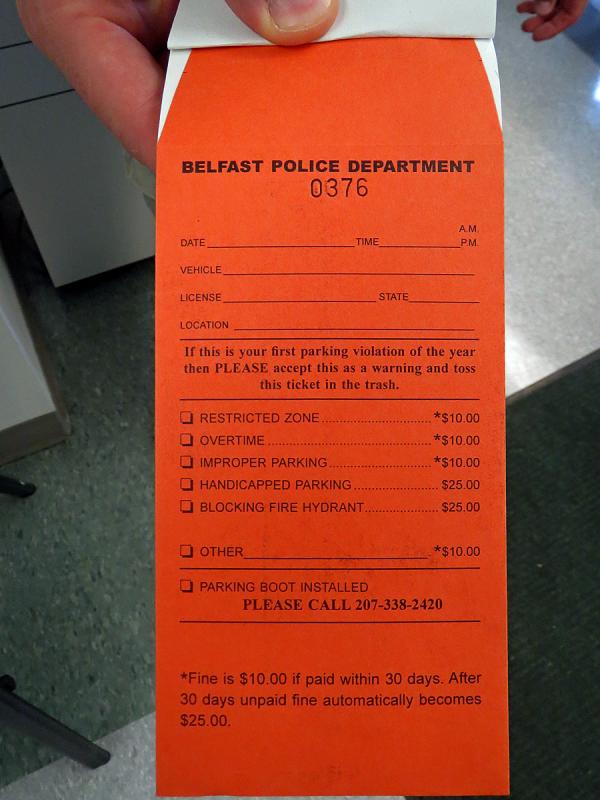 Belfast's new, bright orange parking ticket is self-mailing, eliminating the excuse "I couldn't find an envelope to mail the fine." (Photo by Erica Thoms)