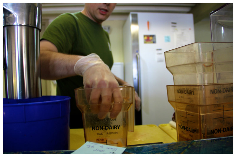 Chris Roberts of The Juice Cellar pulls together ingredients for one of the new business' fresh juice drinks. (Photo by Wes Sterrs)