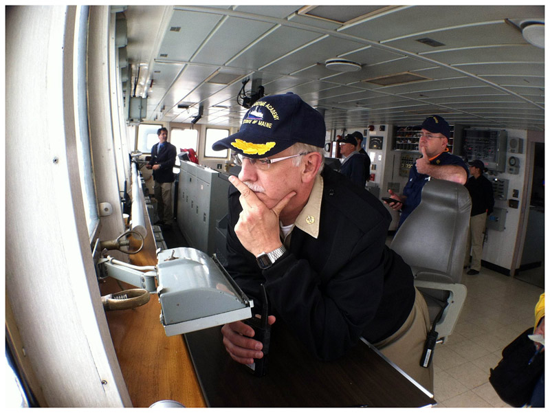Capt. Les Eadie of Maine Maritime Academy's Training Ship State of Maine waits as Capt. David Gelinas of the Penobscot Bay & River Pilots Association, background, left, guides the ship out of port in Castine. (Photo by Ethan Andrews)