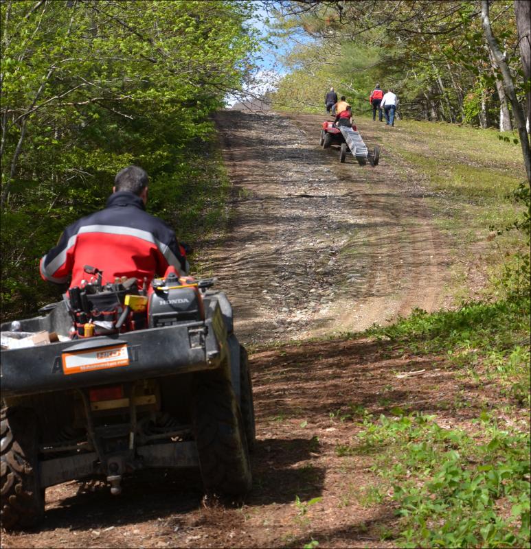 Heading up Ragged Mountain with tools, ladders and workers.