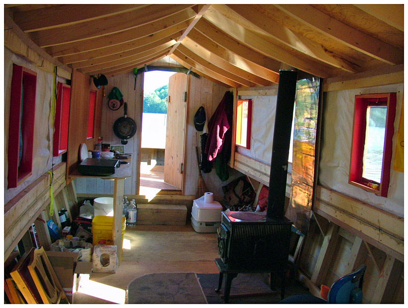 The interior of the cabin, facing aft, is unfinished but includes some basic comforts including a stove, a washbasin and a marine head. (Photo by Ethan Andrews)