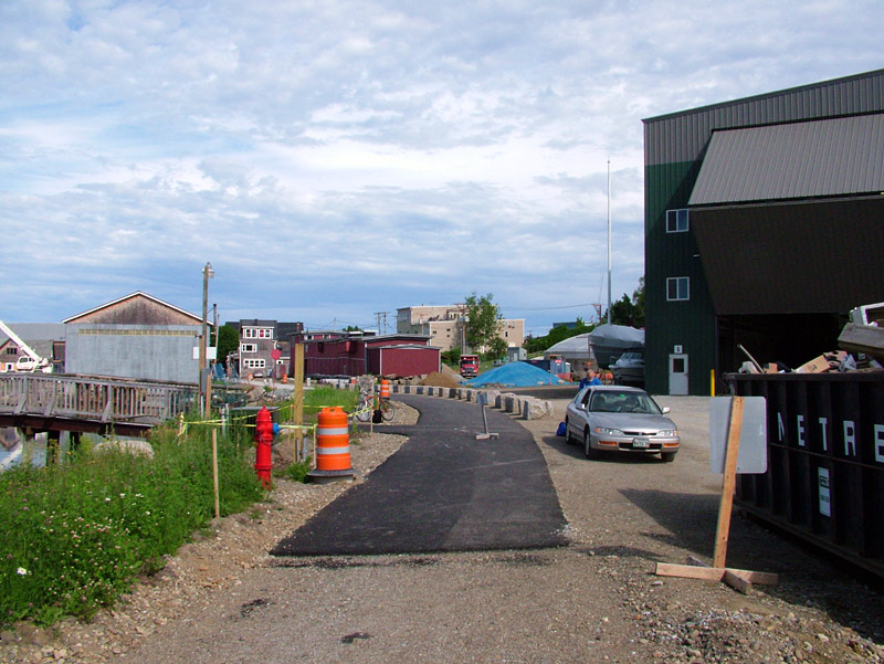 The temporary top end of the Belfast Harbor Walk starts just below the construction site of Front Street Shipyard's new travel lift pier. Heading south from here, the new pedestrian and bicycle path is completely paved through Heritage Park. (Photo by Ethan Andrews)