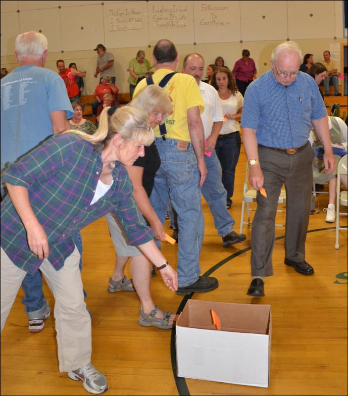 Ginny Ryan drops her paper ballot into the cardboard box. (Photo by Lynda Clancy)