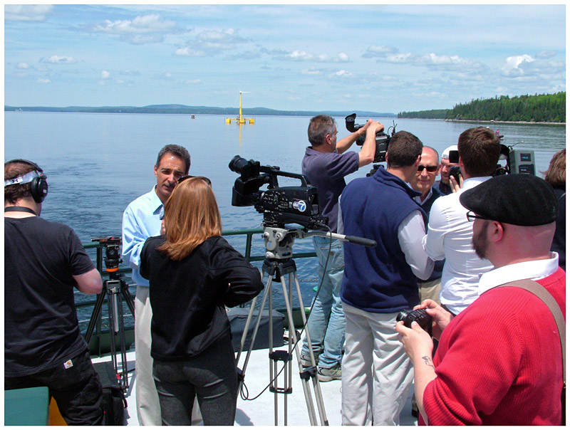 Reporters interview Dr. Habib Dagher, left, and Cianbro CEO and President Peter Vigue, right, with sunglasses. (Photo by Ethan Andrews)
