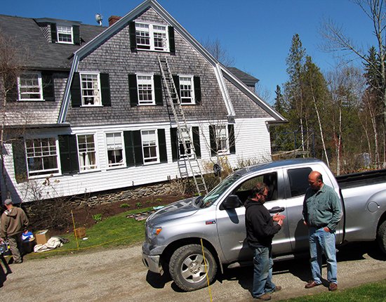 Mike Boucher, right, speaks with Andy Staples, one of the contractors who works on houses Boucher cares for on Islesboro. (Photo courtesy of Tom Groening, Island Institute)