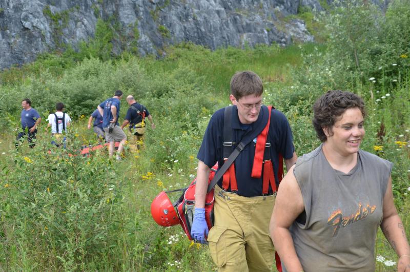 Alisha Penn walks up and out of the quarry area with the help of Rockland and Thomaston firefighters. (Photo by Lynda Clancy)