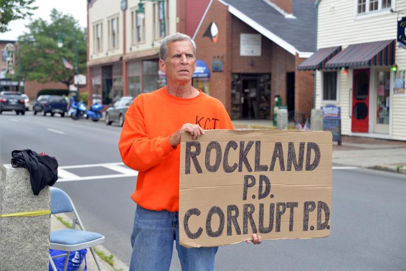 Tom Foy holds his sign claiming that the Rockland PD is corupt. (Photo by Ron Hawkes).
