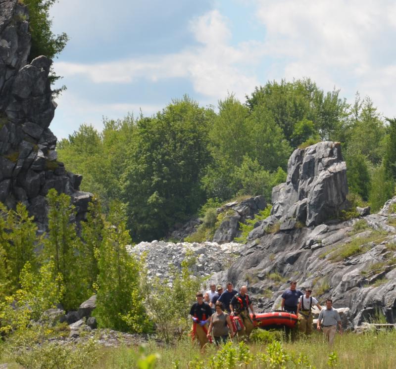 Firefighters walk the Thomaston Fire Department rescue boat up from the swampy area that lies between the quarries. (Photo by Lynda Clancy)